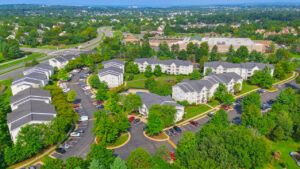 Aerial Exterior of Acclaim at Ashburn, neighborhoods in the background, lush foliage, photo taken on a sunny day.