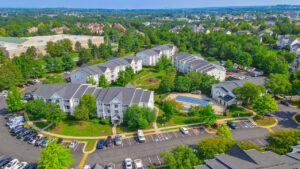 Aerial Exterior of Acclaim at Ashburn, Lush foliage, neighborhoods in the background, photo taken on a sunny day.