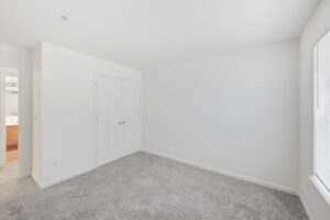 Interior Unit Bedroom, white walls, neutral toned carpeting, 2 doored closet.
